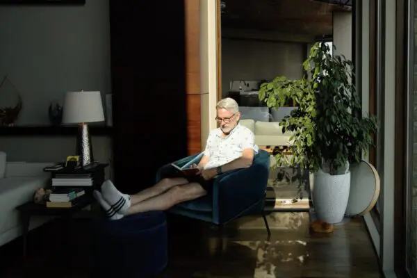 A leader sitting in a chair, half in light and half in shadow, illustrating consciousness work for CEOs
